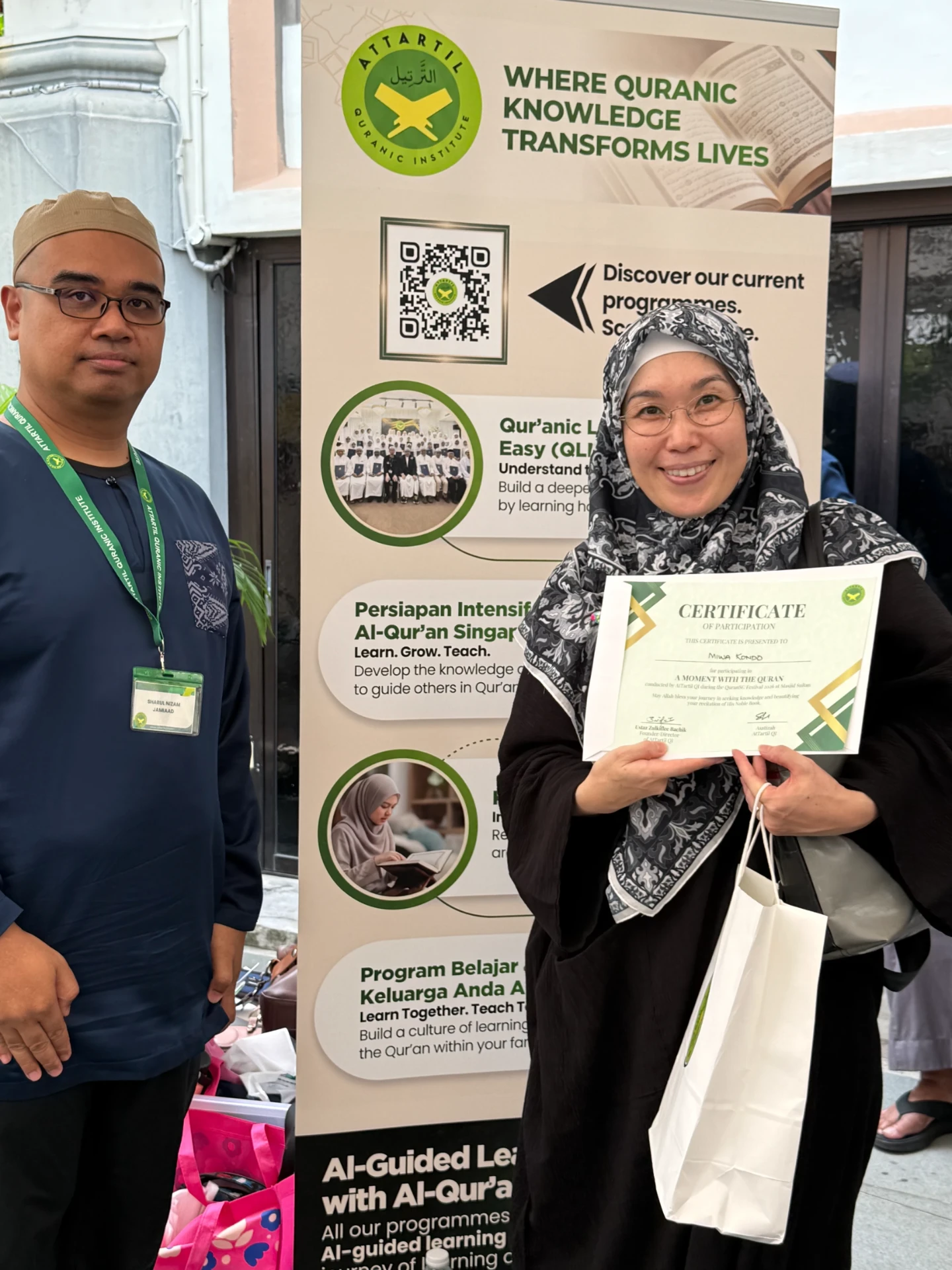 A visitor receiving her 'A Moment With The Quran' certificate