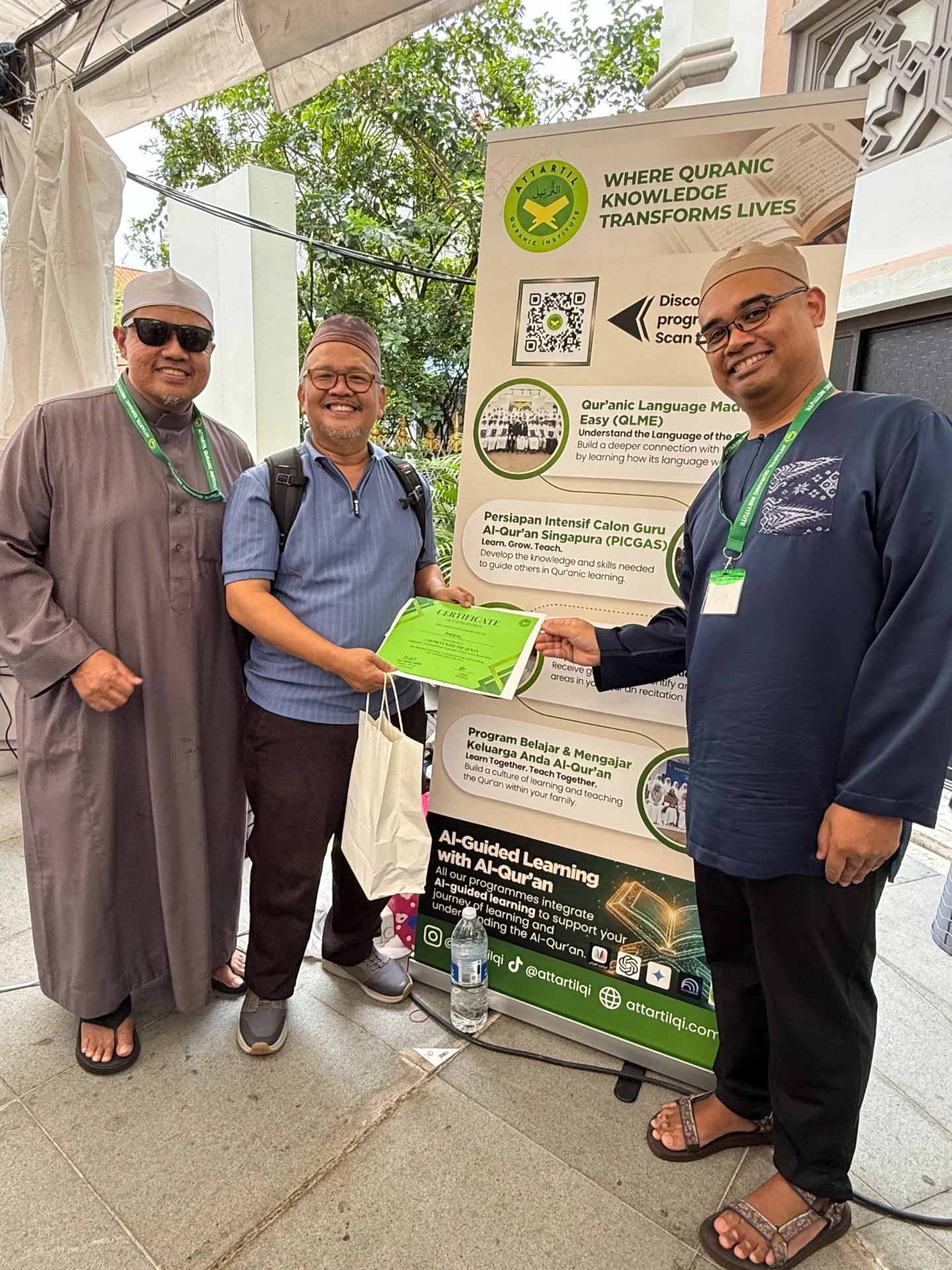 A visitor receiving his certificate alongside AtTartil QI teachers