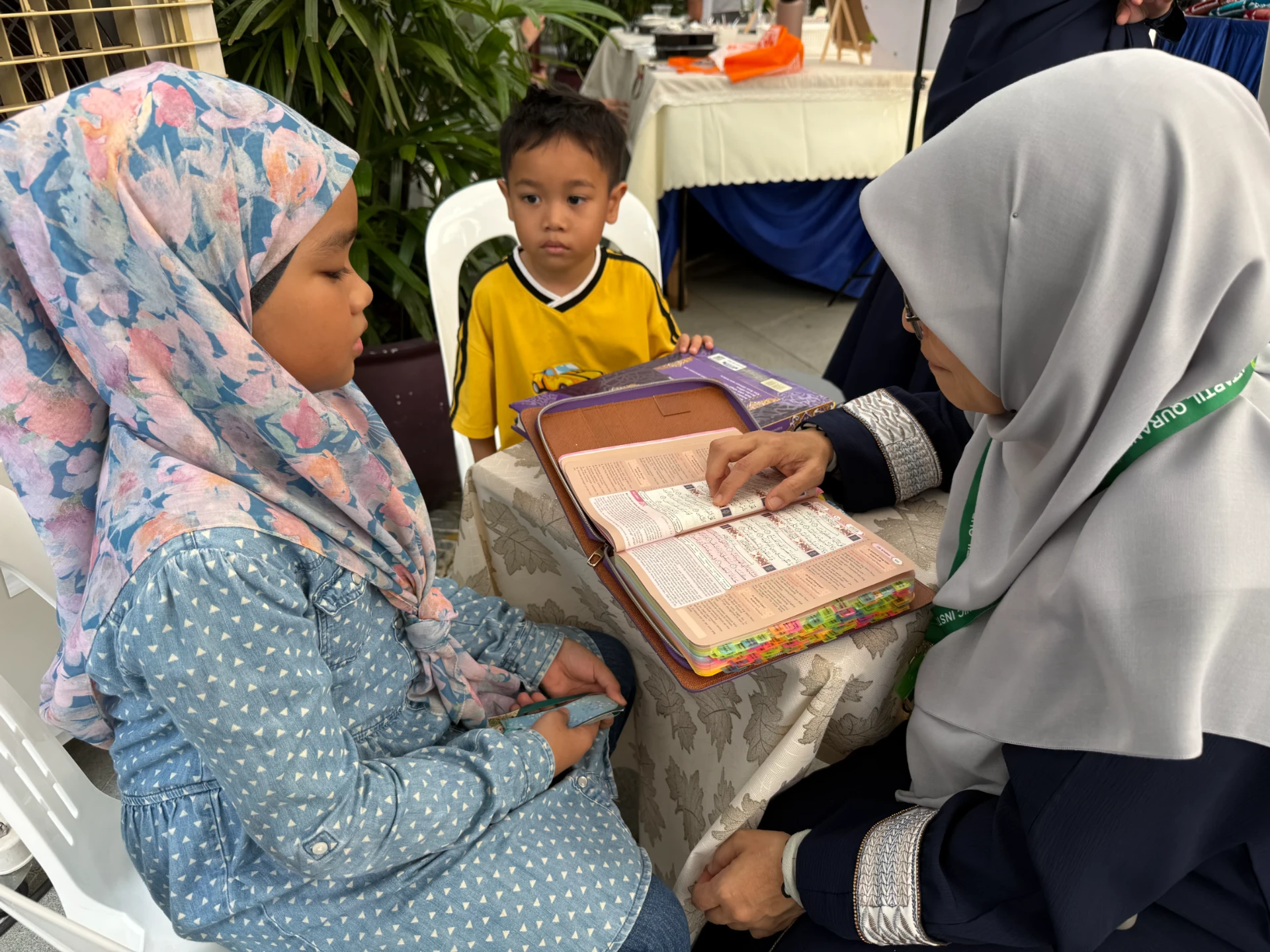 Children reciting with an AtTartil QI teacher at the booth