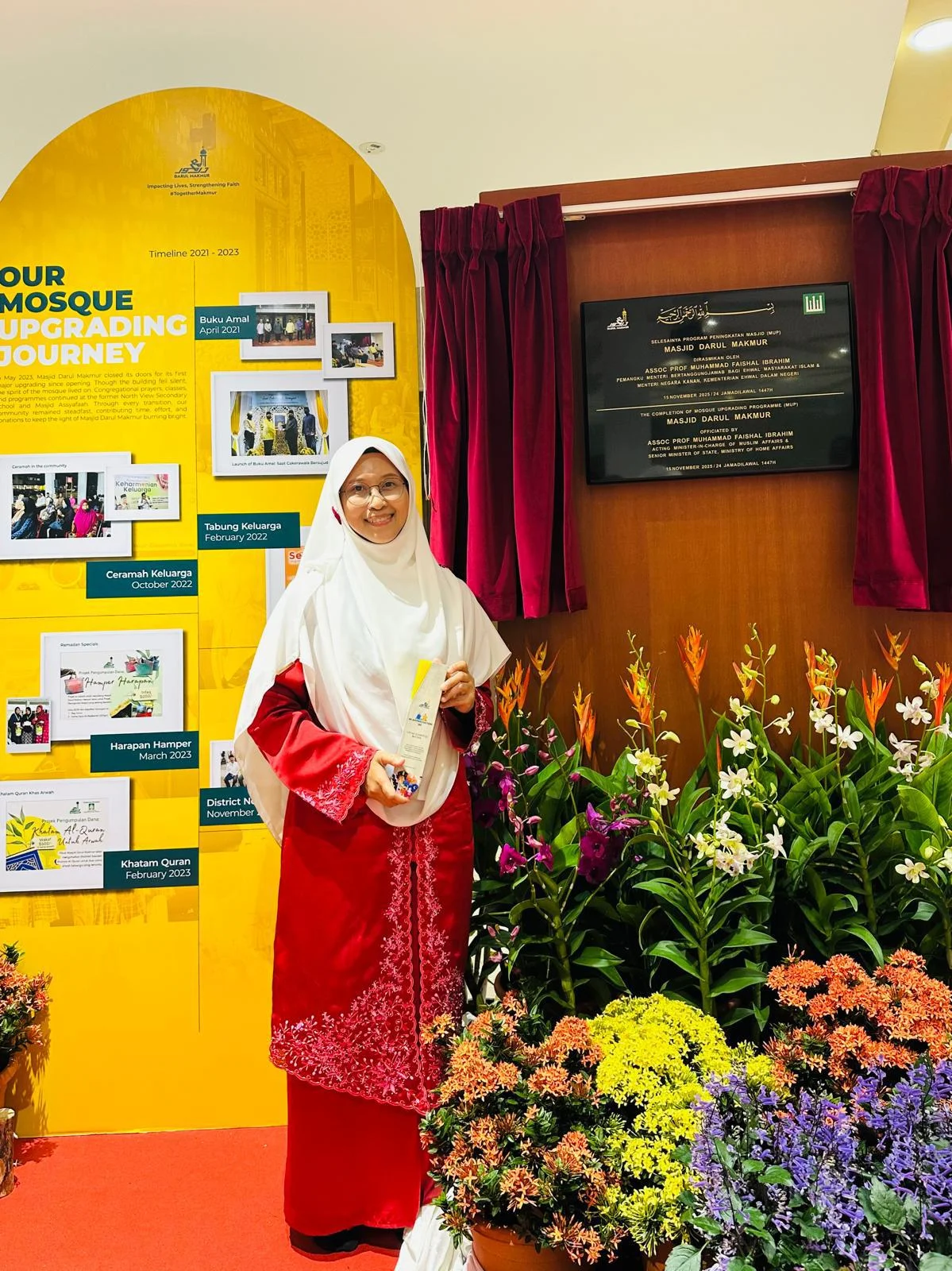 AtTartil QI representative with the appreciation award beside the mosque upgrading plaque