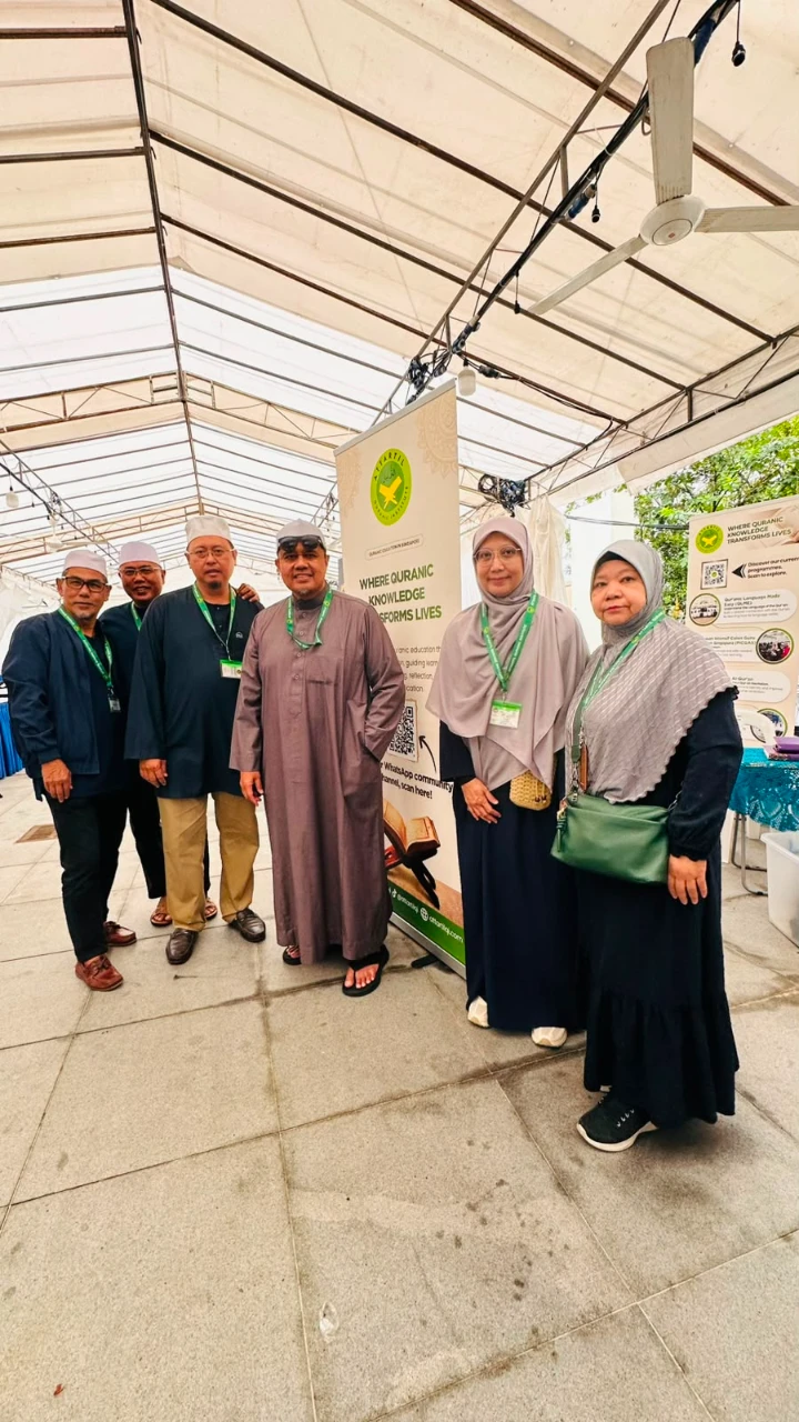 AtTartil QI team members posing beside the booth banner