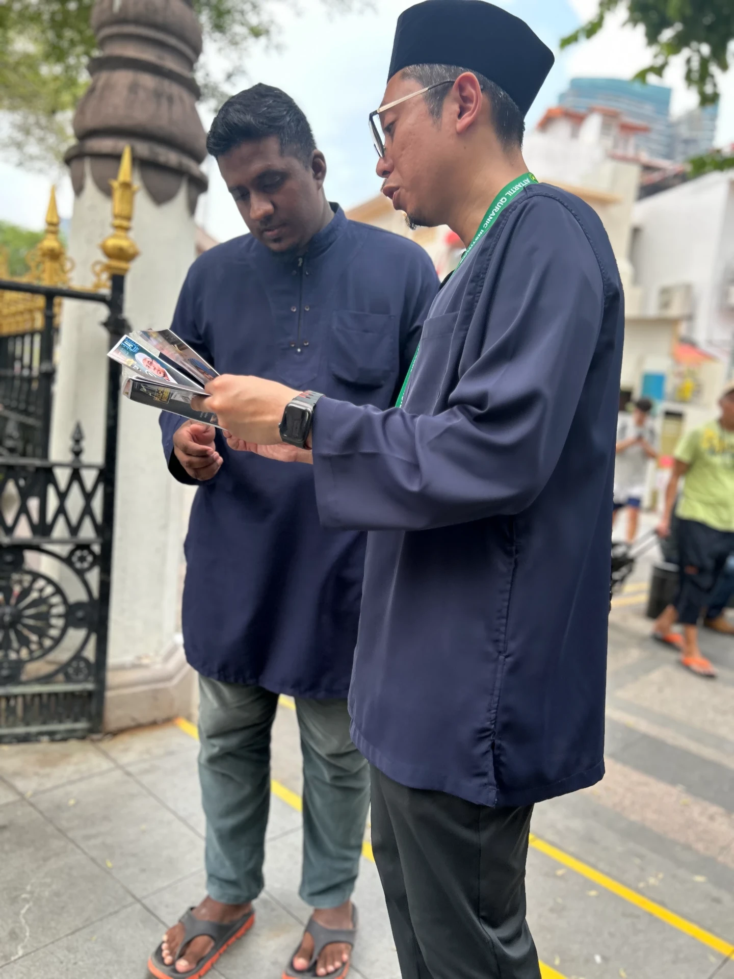 A teacher explaining AtTartil QI programmes to a passer-by