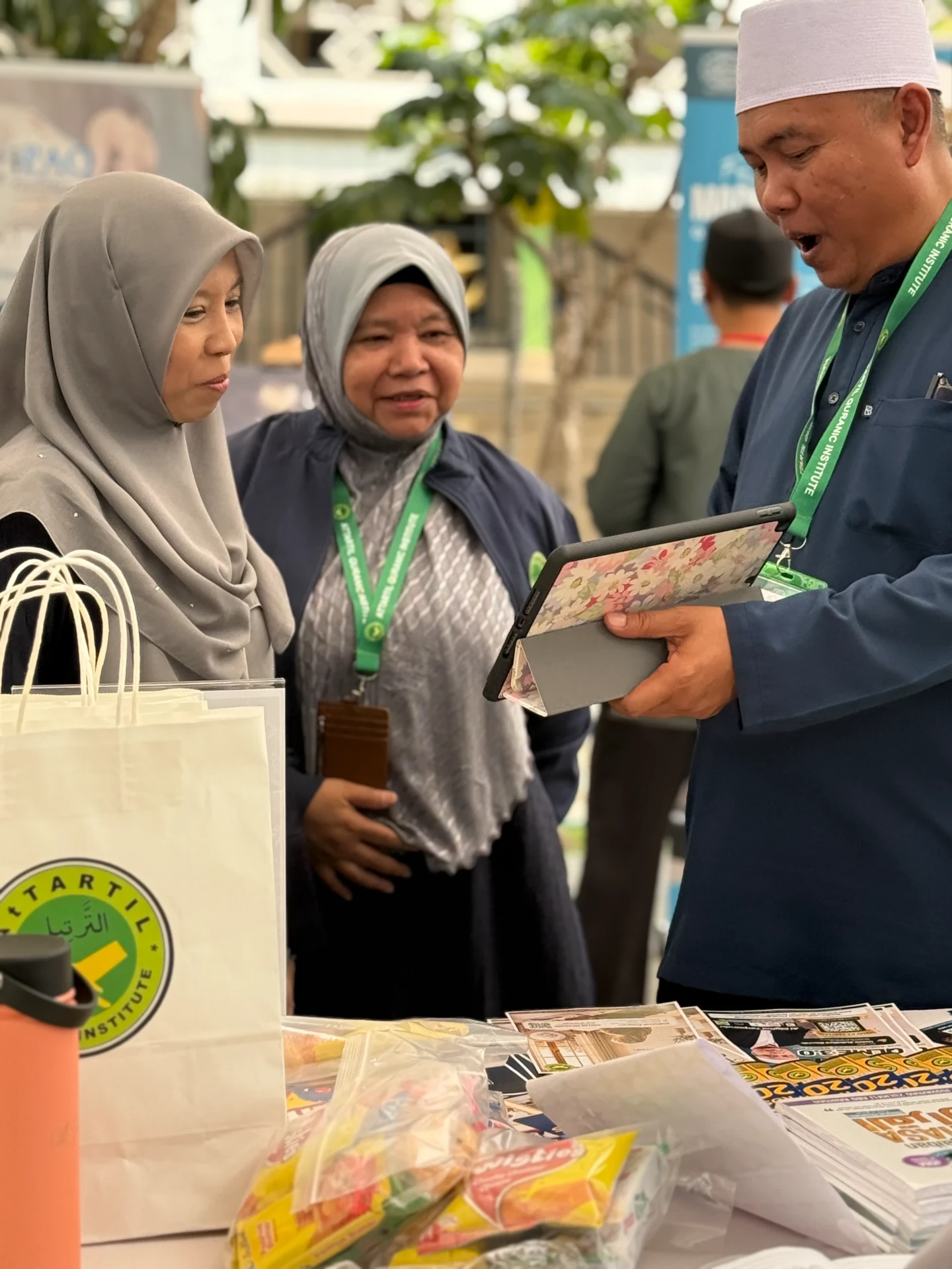 An AtTartil QI teacher sharing programme information with two visitors