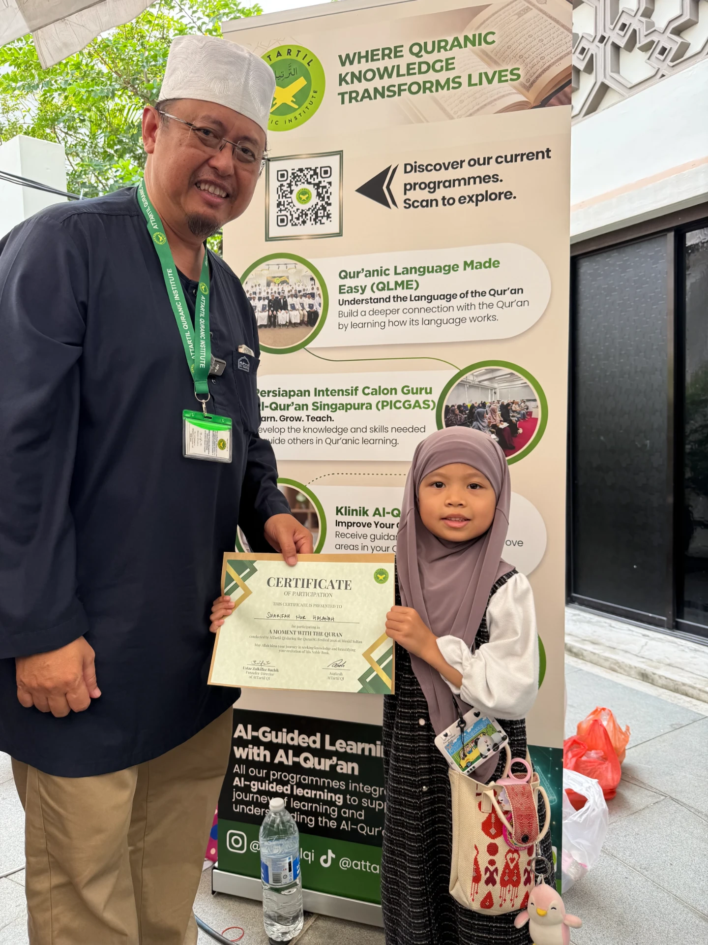 Ustaz Zulkiflee presenting a certificate to a young girl