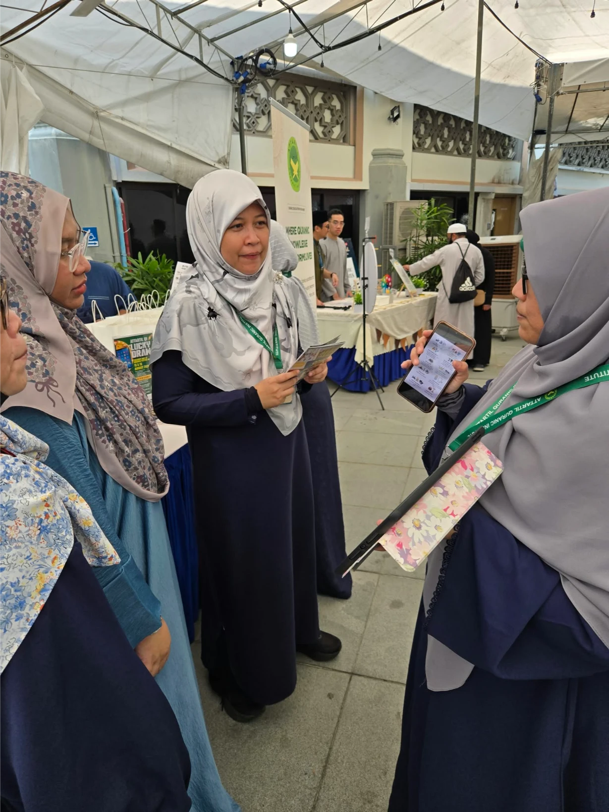 AtTartil QI teacher speaking with visitors at the booth during Quran Festival 2026